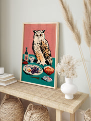 Illustrative art print of a white owl with orange eyes next to a table with grapes, egg, and, in an alternate framed mockup