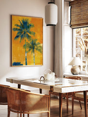 Two tall blue-green palm trees against a vibrant, textured orange and yellow background in a, in a styled room mockup