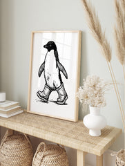 Black and white illustrative print of a penguin wearing rubber wellington boots on a plain, in an alternate framed mockup