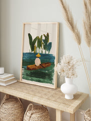 Illustrative painting of person in yellow hat in wooden boat on green-blue water with green, in an alternate framed mockup