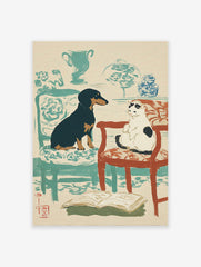 Illustrative pet wall art showing a black dog and a white cat on chairs, with an open book on the floor.