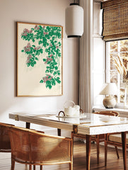 Illustrative botanical print with cascading pink flowers and green leaves on a cream background, in a styled room mockup