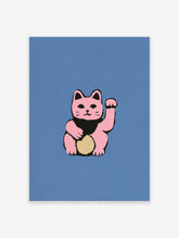 Pink maneki-neko cat illustration with raised paw, black bib, and gold oval on blue background