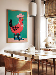 Pink chicken illustration wearing a pink cowboy hat, pearl necklace, and blue cowboy boots on a, in a styled room mockup