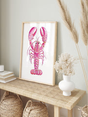 Pink lobster watercolour illustration art print with speckled claws on a white background, in an alternate framed mockup