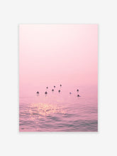 Pink Ocean Surfer Poster featuring multiple surfers waiting in calm, pink-hued water with sun reflections.