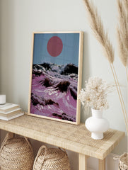 Surreal art print of pink ocean waves crashing with white foam under a large red sun in a, in an alternate framed mockup