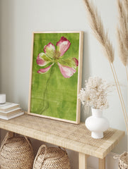 Stylized pink poppy flower illustration with an etched stem against a textured green, in an alternate framed mockup