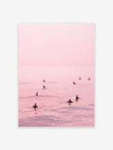 Pink surfer poster showing multiple surfers on a calm, shimmering pink ocean under a pastel sky.