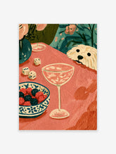 Pink tablescape art print with cream dog, dice, berry bowl, and coupe glass on coral table