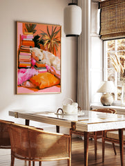 Painterly illustration of a polar bear sleeping on a stack of books with orange and pink tones, in a styled room mockup