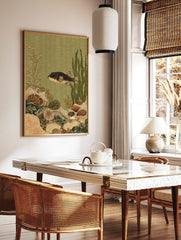 Illustrative pufferfish in an underwater scene with coral, shells, and seaweed in green and beige, in a styled room mockup