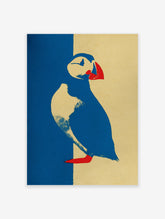 Graphic puffin wall art illustration in blue, yellow, and red on textured paper.