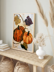 Pumpkin wall art featuring two orange gourds and botanical vines on a cream background, in an alternate framed mockup