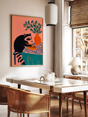 Illustrative raccoon holding a pie on a patterned tablecloth with a vase of green foliage, coral, in a styled room mockup
