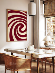 Abstract red and cream spiral wall art with bold, swirling lines and a hypnotic composition, in a styled room mockup
