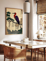 Japanese illustrative print of a red and purple heron on a tree branch with green foliage and, in a styled room mockup