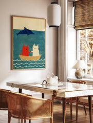 Red and white cat illustration with a blue dolphin in a boat on a blue sea, in a styled room mockup