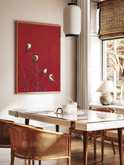 Four red-backed shrike birds on bare branches with red berries against a striking red background, in a styled room mockup