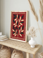 Symmetrical botanical leaf illustration in cream on a deep red background with a decorative, in an alternate framed mockup