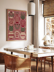 Decorative folk art print showing six patterned vases with botanical flowers and leaves in red, in a styled room mockup