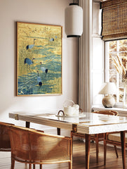 Illustrative print of red-crowned cranes wading in blue water amongst golden reeds with flying birds, in a styled room mockup