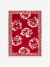 Red and white floral print with Greek key border, stylised blooms on deep red background