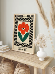 Red flower poster with an eye motif and green leaves, framed by black and cream chevron pattern, for Milan Garden Exhibition. - Image 4