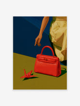 Red handbag and origami crane on olive surface with hand pointing, blue background, modern art print