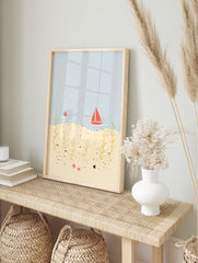 Illustrative coastal scene with red sailboats on blue water, golden seaweed, and red starfish, in an alternate framed mockup