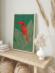 Red toucan bird with long beak perched on large tropical leaves on a green background, in an alternate framed mockup