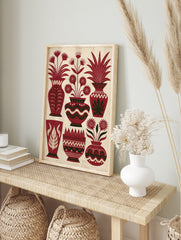 Illustrative red vase wall art with stylized flowers and leafy plants on a textured cream, in an alternate framed mockup