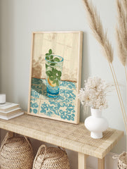 Illustrative refreshing drink wall art with mint, lemon, and ice in a glass on blue patterned tiles against a textured beige wall. - Image 3