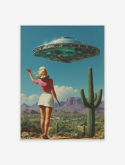 Retro UFO desert wall art featuring a woman waving at a flying saucer above a landscape with cacti and mountains