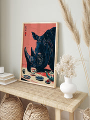 Rhinoceros head in blue, with a tea cup and pot in red and white, on a pink background, in an alternate framed mockup