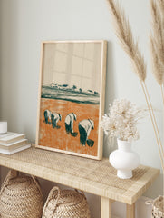 Illustrative print of four figures in conical hats working in an orange rice paddy field with, in an alternate framed mockup