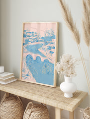 Illustrative riverside village wall art with pink and blue houses, a bridge over a river, and bare trees. - Image 3