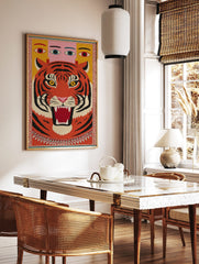 Bold illustrative roaring tiger wall art with multi-eyed figure on yellow background, framed by, in a styled room mockup