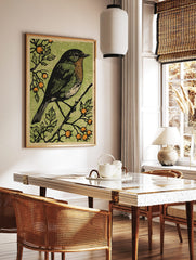 Woodcut style art print of a robin bird with orange breast on a branch with green leaves and orange, in a styled room mockup
