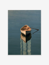 A wooden rowing boat floating on calm blue water with a detailed reflection, presented as a minimalist nautical art print