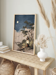 Illustrative rustic lantern glowing by railway tracks under a full moon in a blue night sky, in an alternate framed mockup