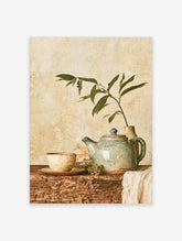 Rustic still life poster with crackle-glaze teapot, ceramic cup, and green sprig on weathered wood