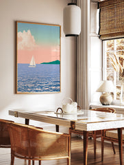 Illustration of a sailboat on blue water with a distant green headland under a soft pink pastel sky, in a styled room mockup