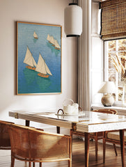 Overhead view of multiple sailboats with white sails and orange hulls on blue and green water, in a, in a styled room mockup