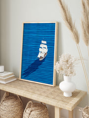 Illustrative sailboat wall art on a blue ocean with horizontal waves and a long shadow, featuring a white boat with brown accents. - Image 3