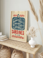 Vintage illustrative print of three blue sardines in a tin, with 'Sardines De L'La Mer' text, in an alternate framed mockup