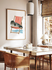 Watercolour illustration of a grey spotted seal sleeping in a red and white striped deck chair on a, in a styled room mockup
