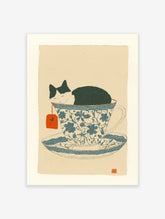Whimsical cat art print showing a black and white cat sleeping soundly inside a blue and white patterned teacup.