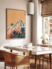 Illustrative print of snow-capped mountains with red streaks and dark blue-green foliage against an, in a styled room mockup