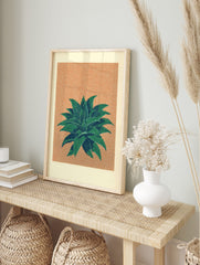 Illustrative green succulent plant with spiky leaves on a textured peach-orange background, in an alternate framed mockup